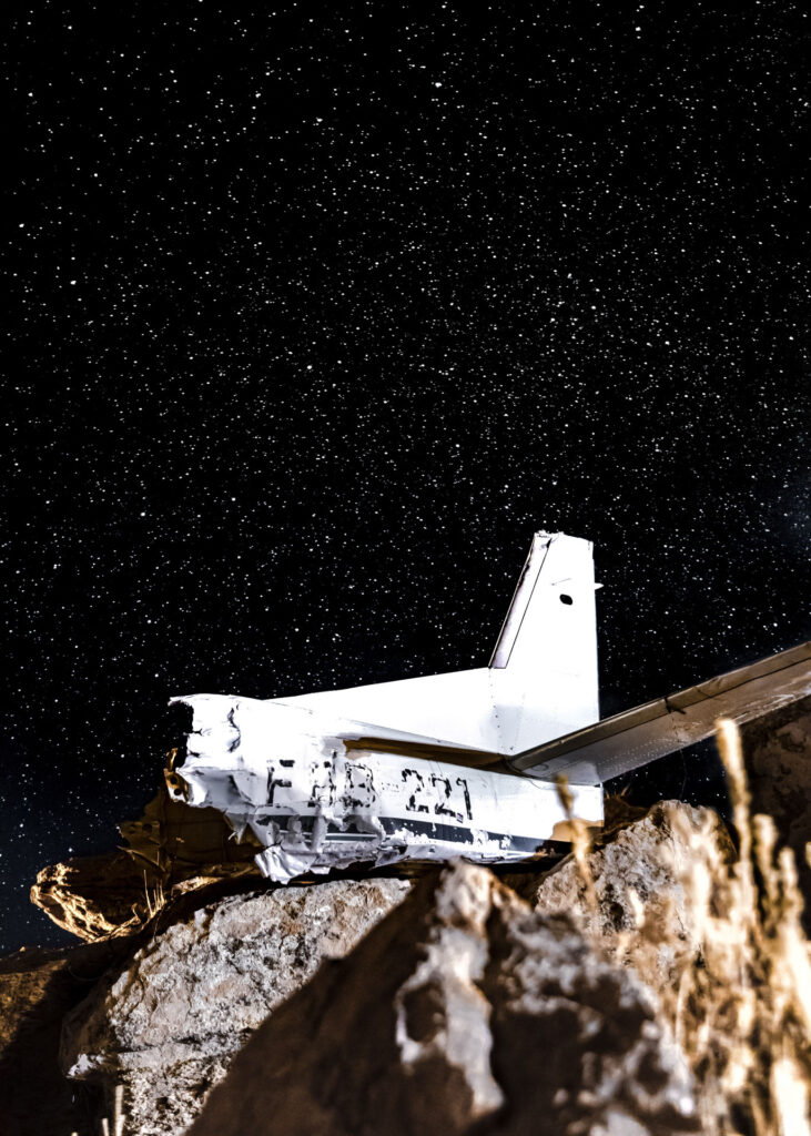 Nous faisons halte dans un village non loin de Tupiza, c'est la fête annuelle. Une chaîne humaine se crée et nous permet de lier avec les personnalités locales. Un habitant voit mon appareil photo et me parle d'un avion qui veillerait tel un Christ au dessus du village. De nuit, je décide d'aller voir...